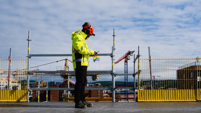 En mann i arbeidsklær. Byggeplass.